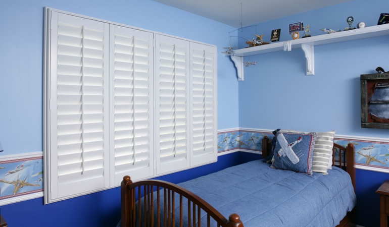 Blue kids bedroom with white plantation shutters in Boston
